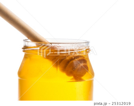 opened honey jar on white background with wooden honey dipper inside opened honey jar on white background with wooden honey dipper inside 25312019