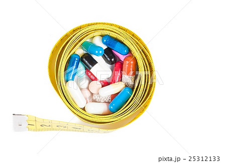 top of view of medical blue pills in front of measure tape, concept for diet top of view of medical blue pills in front of measure tape, concept for diet 25312133