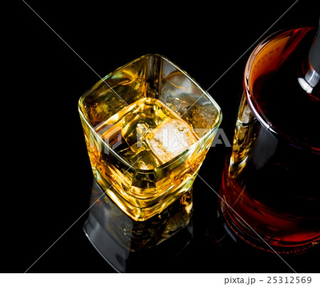 top of view of whiskey with ice in glass on black background top of view of whiskey with ice in glass on black background 25312569