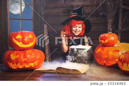 Halloween. child girl witch preparing  potion in cauldron with p 25316463