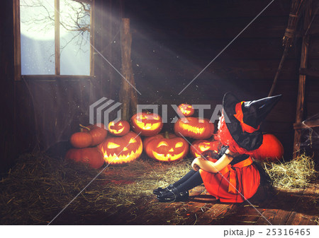 Halloween. child little witch with pumpkin  by the window waitin 25316465