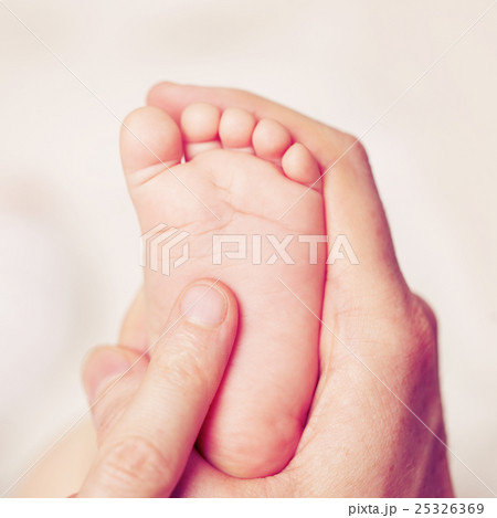 Male hand with baby feet, parental care Male hand with baby feet, parental care 25326369