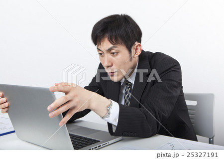 パソコンの前で悩むビジネスマン 25327191