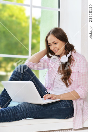 young woman  in headphones with laptop 25328139