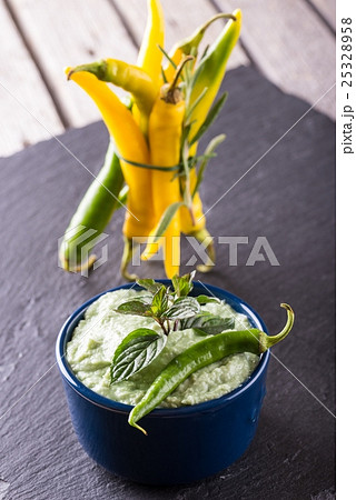 Blue bowl with wasabi dip and several chili pepper Blue bowl with wasabi dip and several chili pepper 25328958