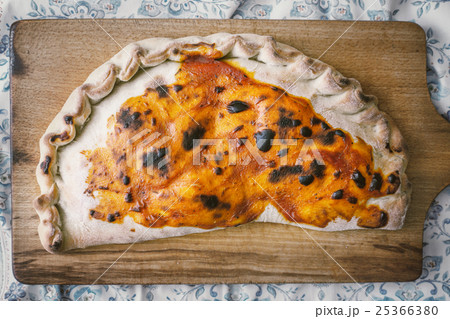 Calzone on the wooden board top view 25366380