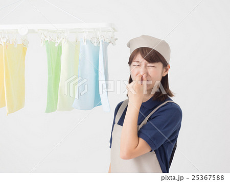室内干しした洗濯物が臭くて鼻をつまむ女性 25367588
