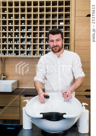 Portrait of happy hairstylist with water tap near Portrait of happy hairstylist with water tap near 25370613