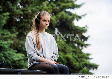 Cheerful athletic woman sitting resting after 25371037