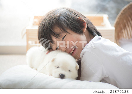 asian child playing with siberian husky puppy 25376188