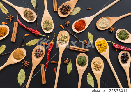 Various spices in wooden spoons. 25378011