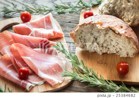 Slices of jamon on the wooden board Slices of jamon on the wooden board 25384682