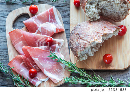Slices of jamon on the wooden board Slices of jamon on the wooden board 25384683