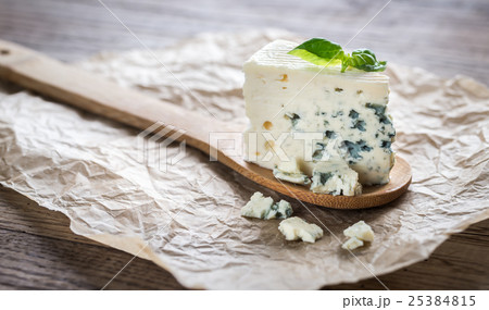 Piece of the blue cheese on the wooden spoon 25384815