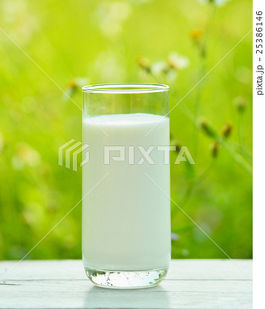 Glass of milk  on white  table  in morning garden 25386146