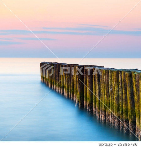 sunset on the beach with a wooden breakwater sunset on the beach with a wooden breakwater 25386736
