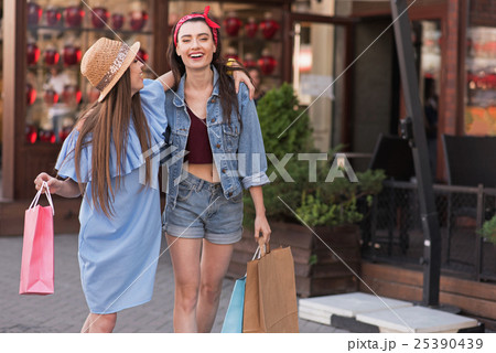 two pretty girls standing on the street with bags two pretty girls standing on the street with bags 25390439