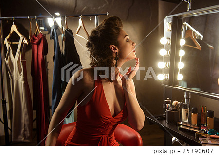 Confident young woman preening in dressing room Confident young woman preening in dressing room 25390607