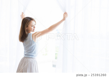 カーテンを開ける女性 25391260