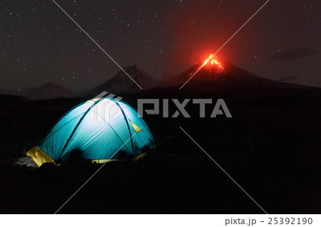 Illuminated tourist tent on background volcano 25392190