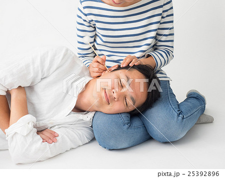 膝枕で耳掻きをしてもらう男性の写真素材