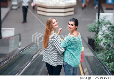 Women with bags on the moving staircase Women with bags on the moving staircase 25393541
