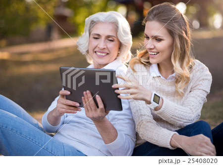 Two delighted smiling woman using tablet. 25408020
