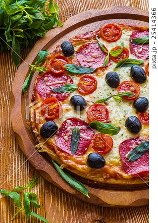 Pizza with salami, black olives and tomatoes 25414366