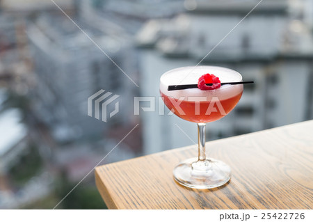 Red cocktail with cherry on table top 25422726