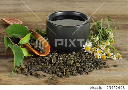 Tea - cup, green leaf and camomile on background Tea - cup, green leaf and camomile on background 25422998