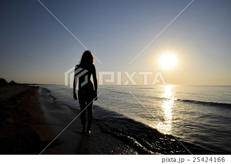 Silhouette of a girl against the sunset by the sea 25424166