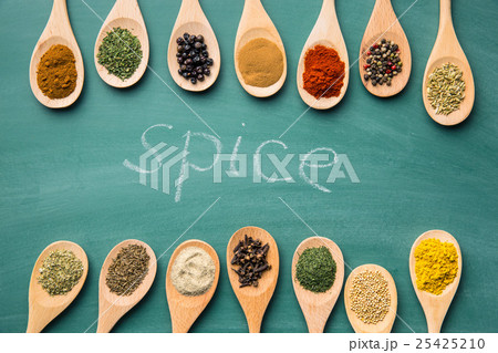 Various spices in wooden spoons. 25425210