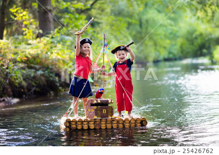 Kids playing pirate adventure on wooden raft 25426762