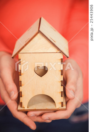 Women's hands with a wooden house 25443906