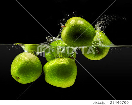 Group of green apples falling in water on black Group of green apples falling in water on black 25446700