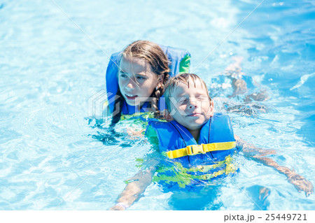 Boy and girl floating in water with life vest 25449721