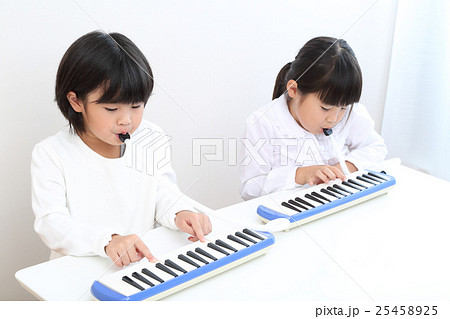 鍵盤ハーモニカを練習する小学生の写真素材