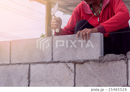 bricklayer installing  brick with trow 25465529