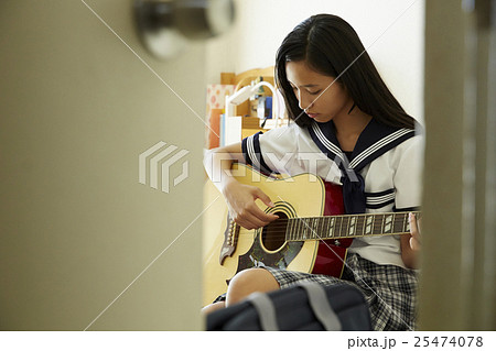 ギターを弾く女子高生の写真素材 ギターを弾く女子高生の写真素材