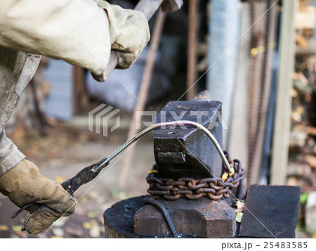 blacksmith forges iron rod on an anvil 25483585