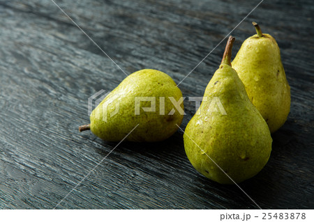 Three green pear on a black background Three green pear on a black background 25483878