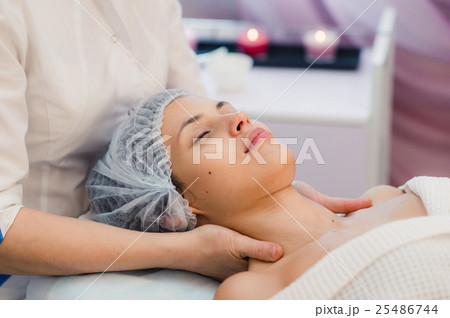 Beautiful young woman relaxing with face massage 25486744