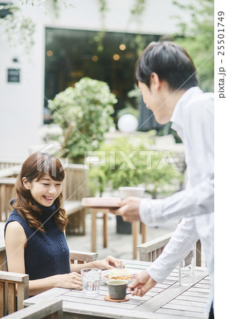 男性店員からコーヒーを受け取る女性客 男性店員からコーヒーを受け取る女性客 25501749