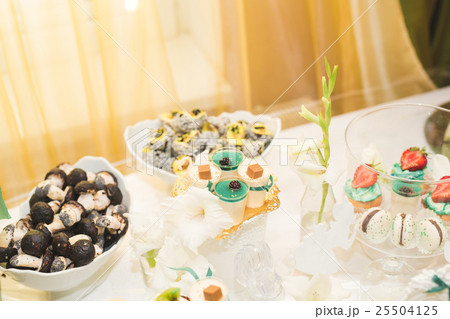 Delicious and tasty dessert table with cupcakes Delicious and tasty dessert table with cupcakes 25504125