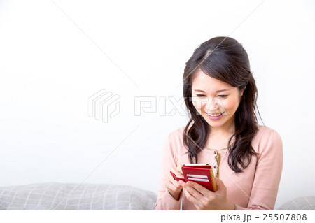 屋内で携帯電話で調べ物をする女性 検索 携帯をいじる スマートフォン スマホ 手元 パーツ Arの写真素材