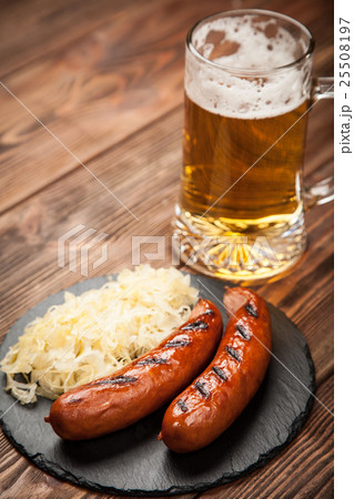 Pretzels, bratwurst and sauerkraut on wooden table Pretzels, bratwurst and sauerkraut on wooden table 25508197