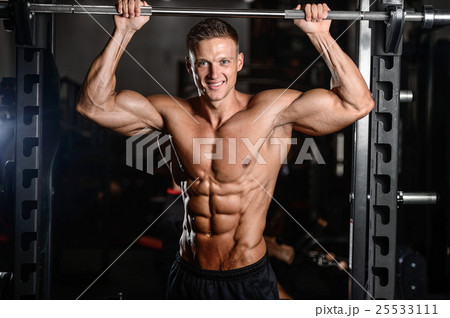 Strong athletic man fitness model showing six pack abs 25533111