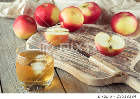 glass of juice and apples on a cutting board glass of juice and apples on a cutting board 25533334