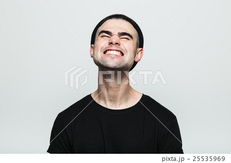 Man feeling exquisite pain while grinning 25535969