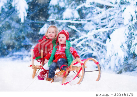 Kids having fun on a sleigh ride in winter 25536279